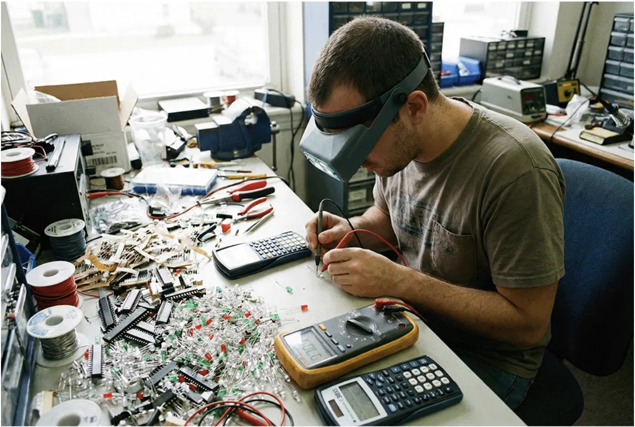 A man using a digital multimeter to check the voltage on LEDs.